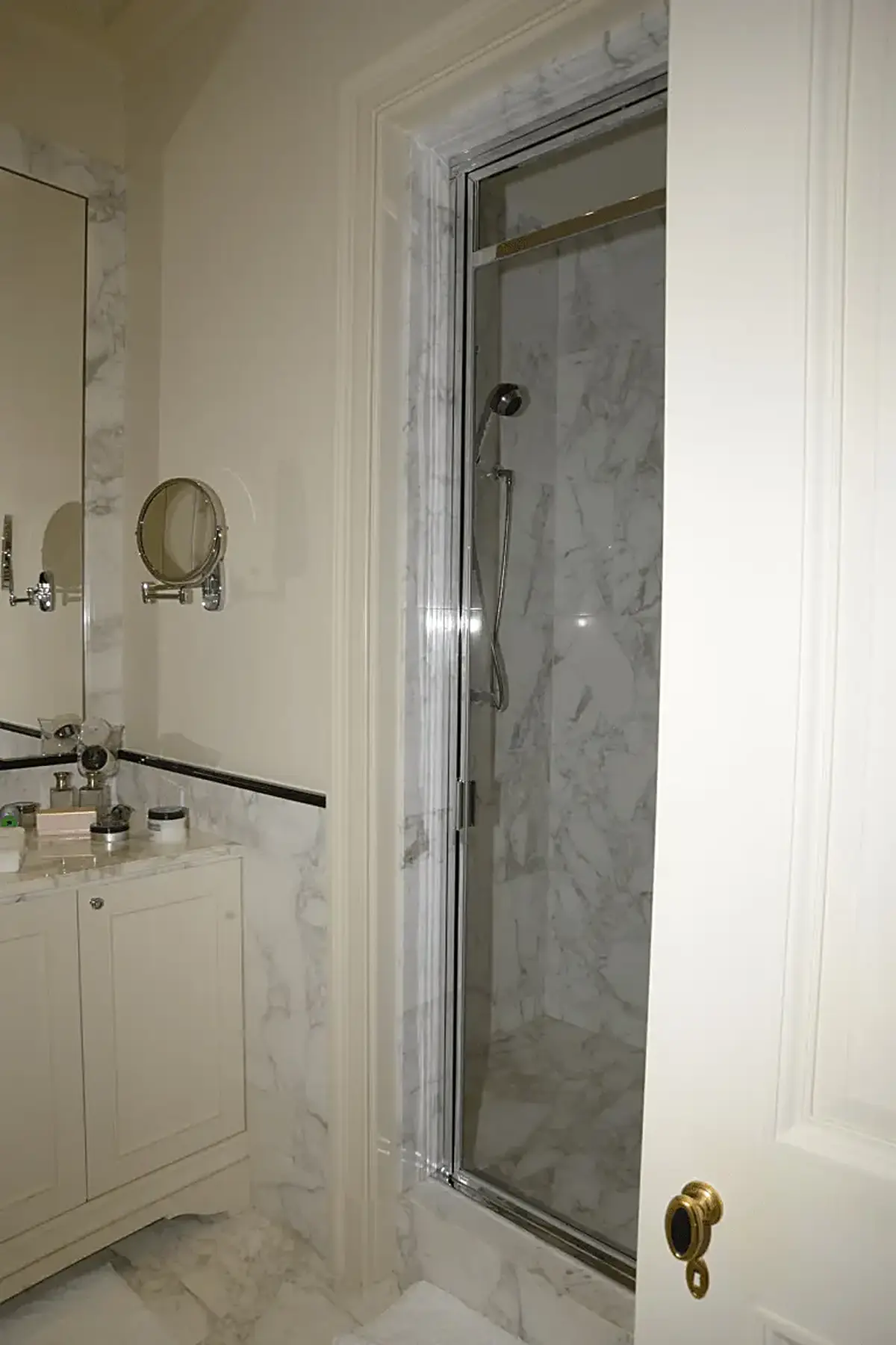 Bathroom: EFTA00000240 - Bathroom featuring marble walls a glass shower enclosure a vanity with toil