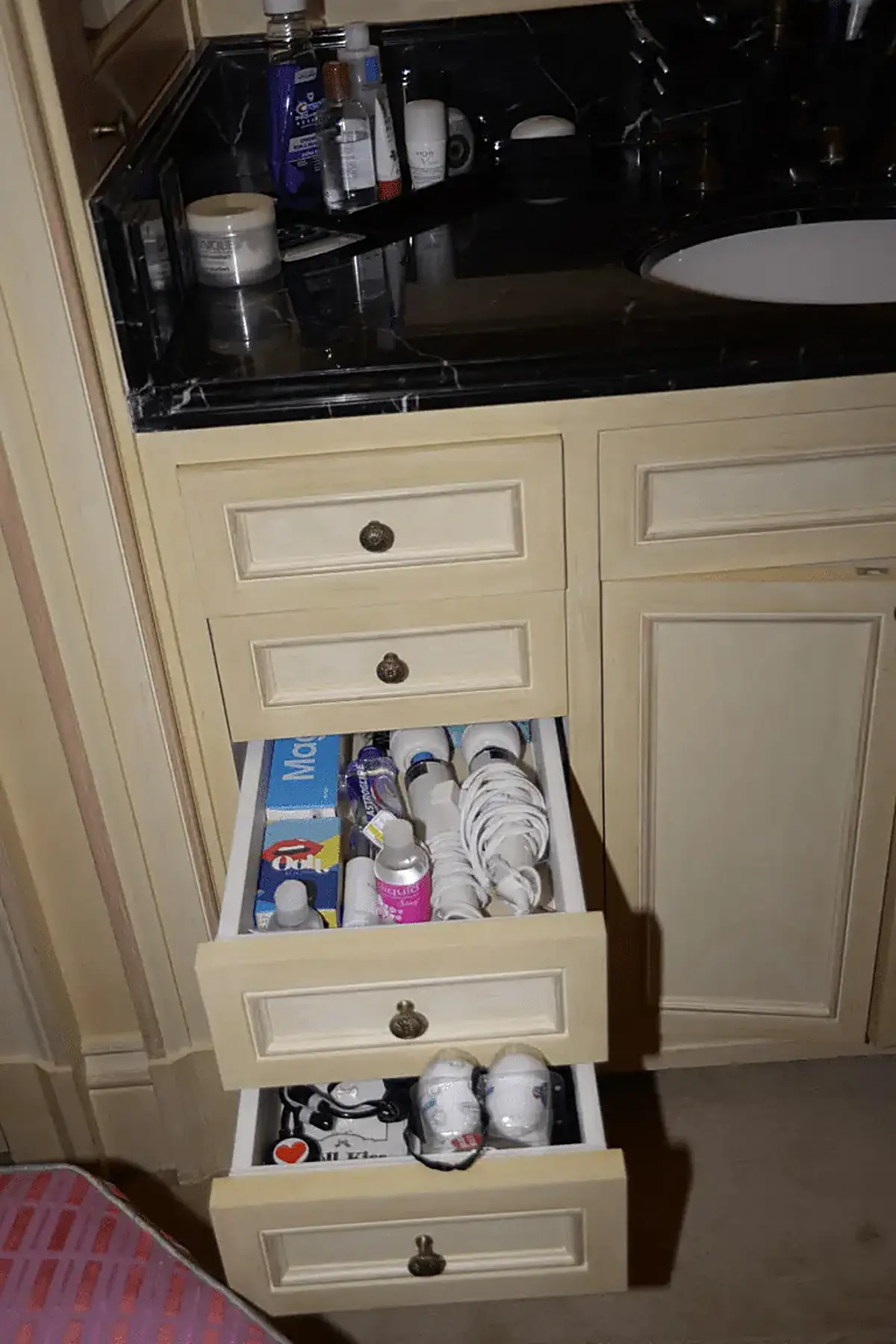 Bagno: EFTA00000505 - Bathroom vanity with open drawers revealing toiletries toothbrushes and per