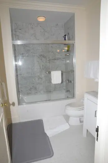 Badezimmer: EFTA00000562 - Clean bathroom featuring a marble-tiled shower white toilet and tiled floor