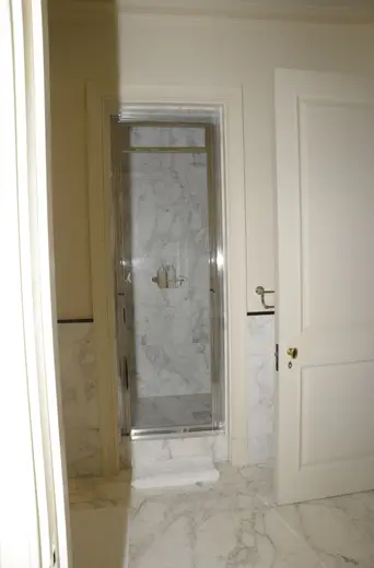 Baño: EFTA00000243 - Modern bathroom featuring a glass shower enclosure with marble walls comple