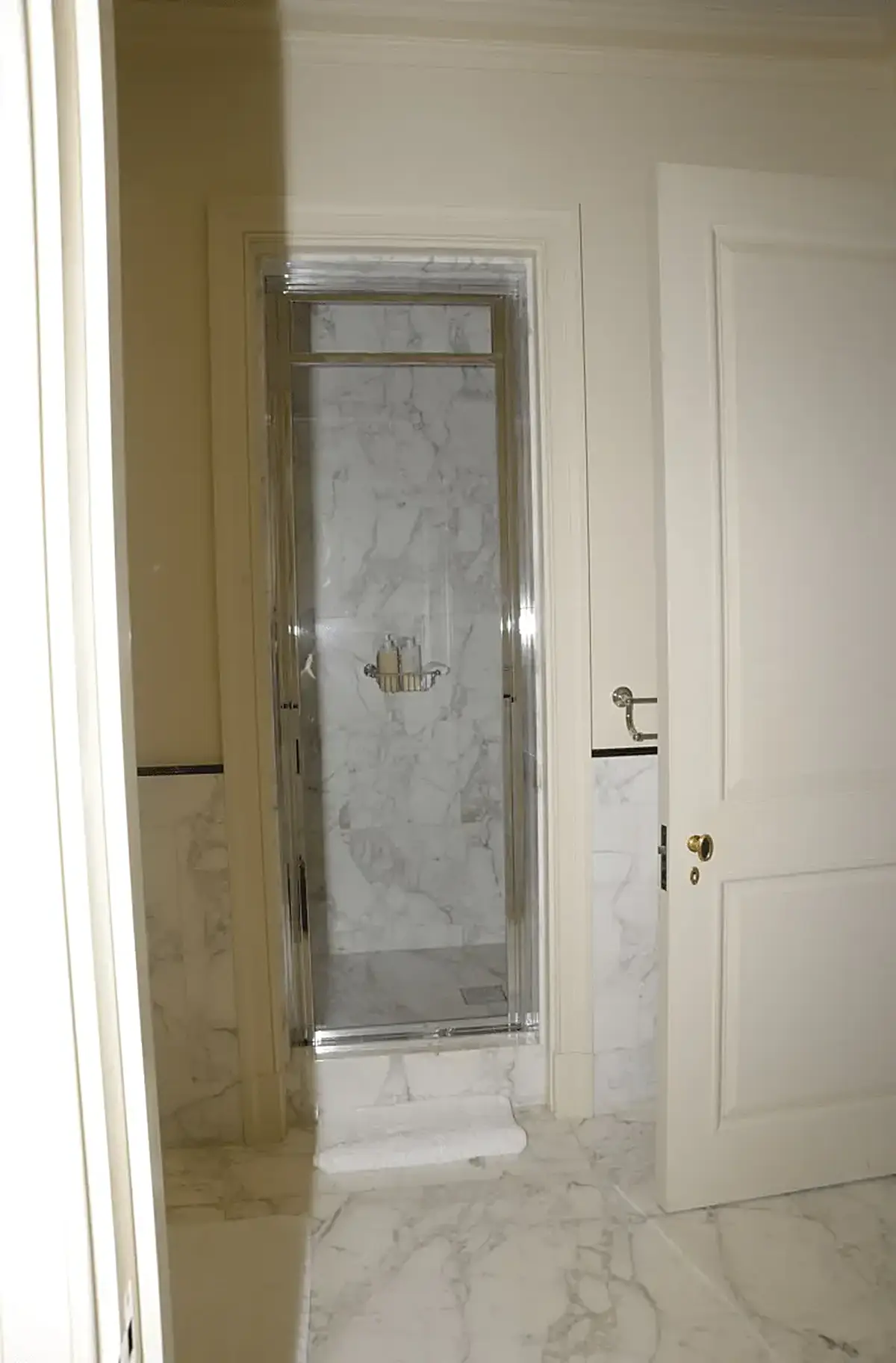 Salle de bains: EFTA00000243 - Modern bathroom featuring a glass shower enclosure with marble walls comple