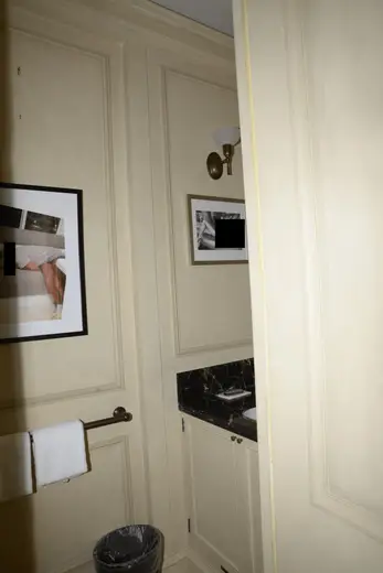 Badezimmer: EFTA00000637 - Bathroom with cream walls framed artwork a black marble countertop and a to