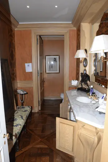 Badezimmer: EFTA00001027 - Luxurious bathroom with wooden floors ornate wall paneling a marble counter