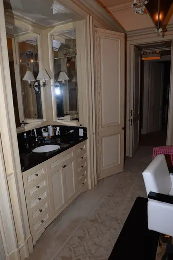 Badezimmer: EFTA00001062 - Luxurious bathroom with a black marble countertop cream-colored cabinetry a