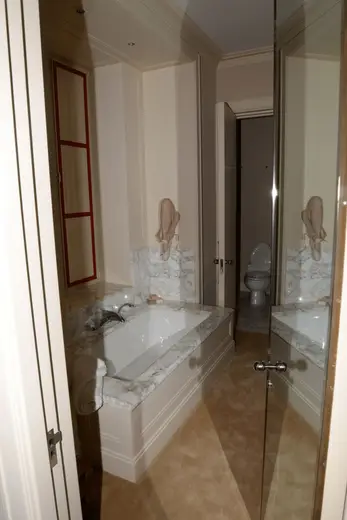 Badezimmer: EFTA00001138 - Luxurious bathroom featuring a white bathtub with marble countertops a red-