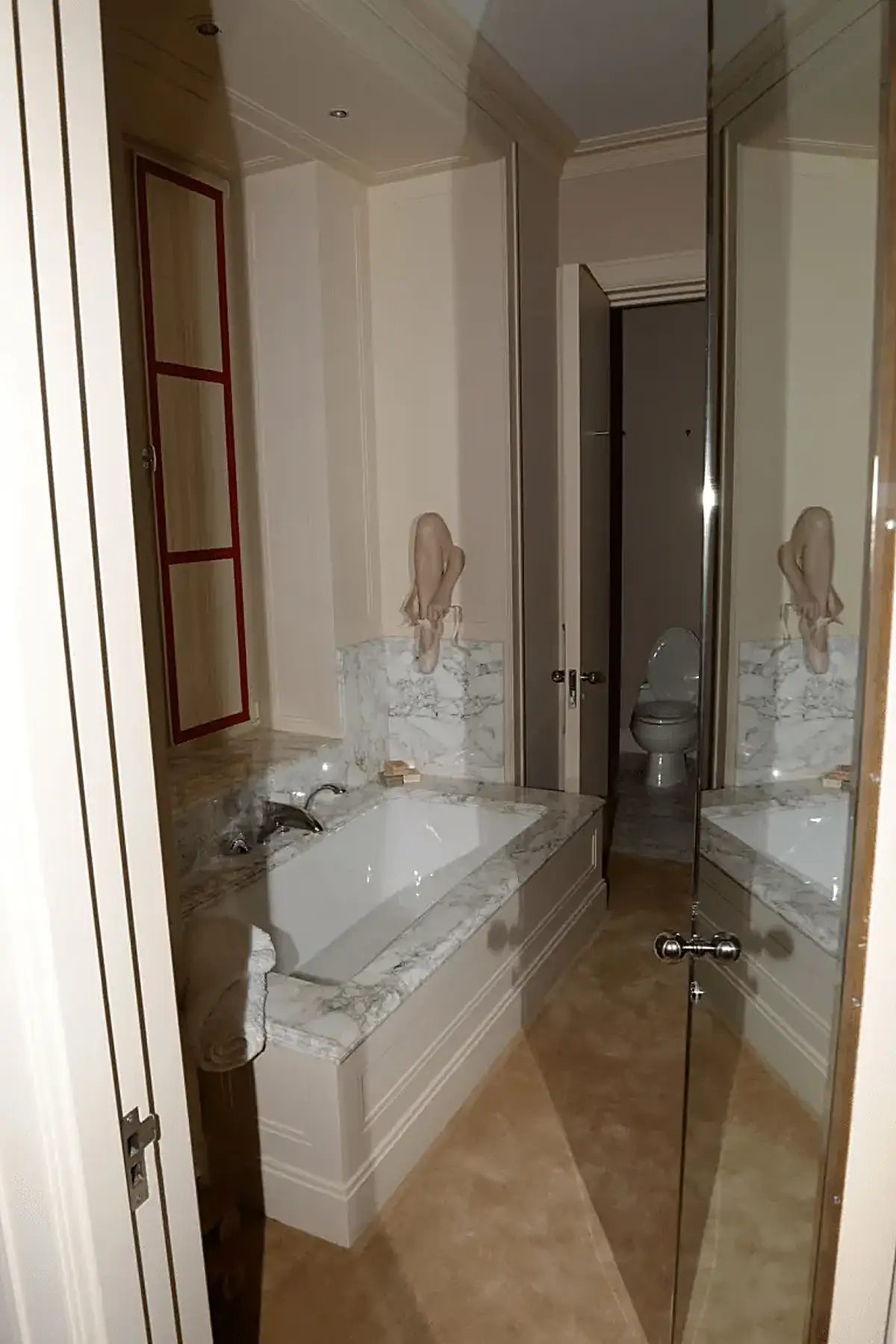 Salle de bains: EFTA00001138 - Luxurious bathroom featuring a white bathtub with marble countertops a red-