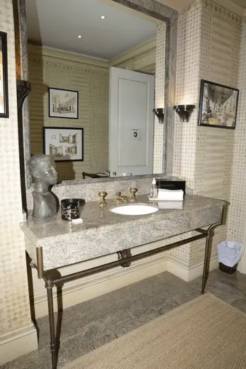 Ванная: EFTA00000048 - Elegant bathroom vanity with marble countertop brass fixtures and patterned