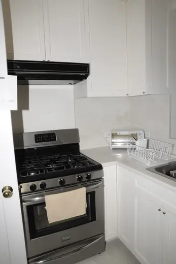 Badezimmer: EFTA00000566 - Modern kitchen with white cabinets a stainless steel gas range and a counte