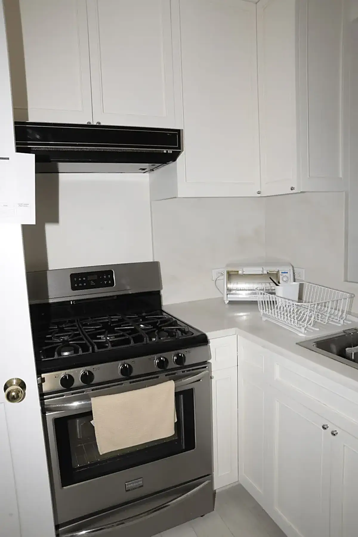 Ванная: EFTA00000566 - Modern kitchen with white cabinets a stainless steel gas range and a counte