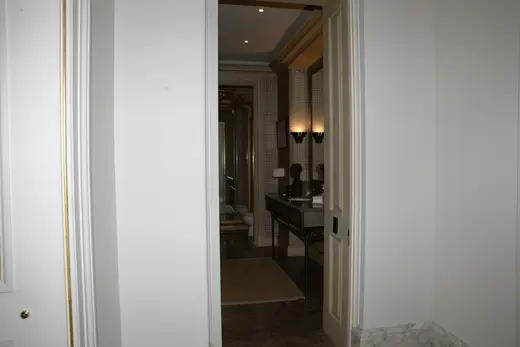 Ванная: EFTA00000043 - View through an open doorway into a luxurious bathroom featuring marble flo