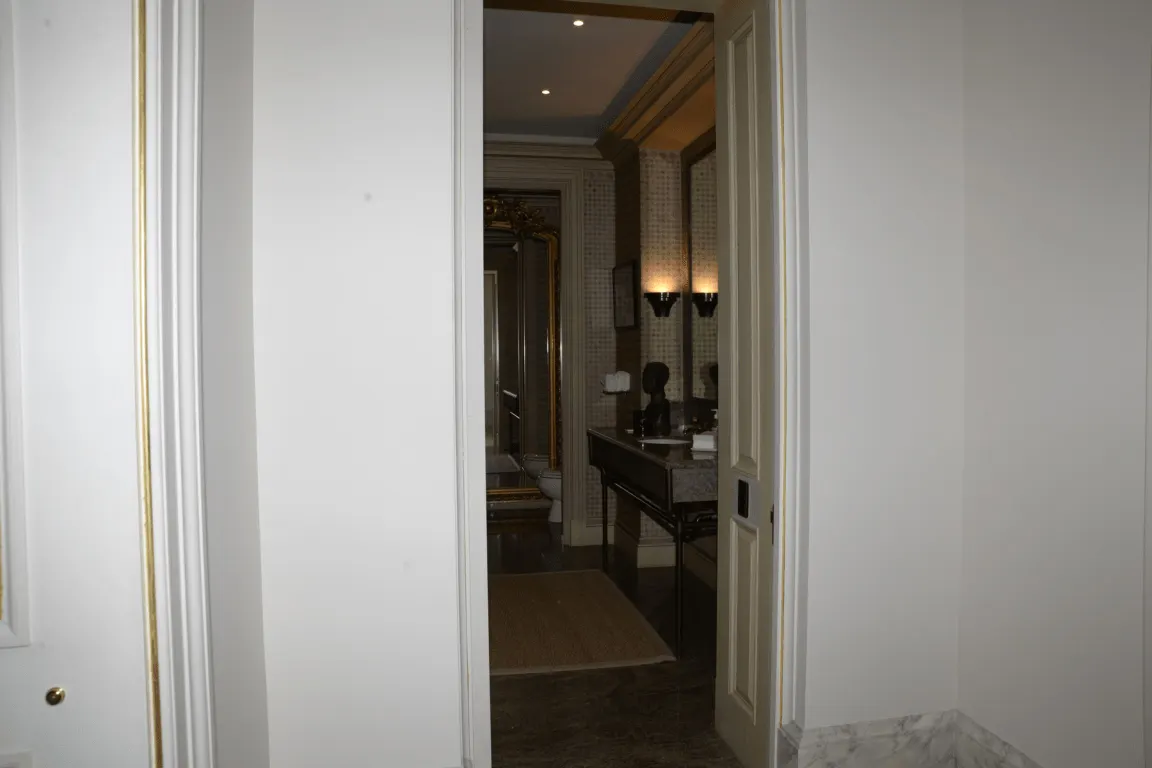 Baño: EFTA00000043 - View through an open doorway into a luxurious bathroom featuring marble flo