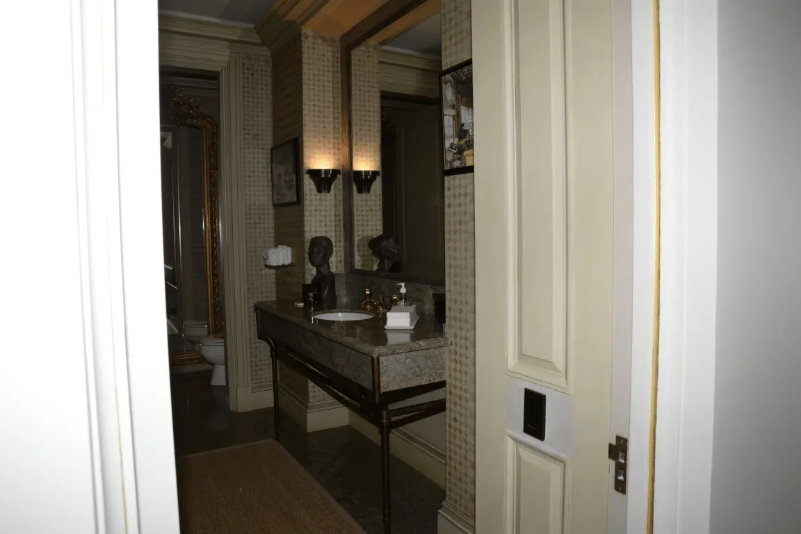 Ванная: EFTA00000046 - Luxurious bathroom with a marble countertop ornate gold-framed mirror and p