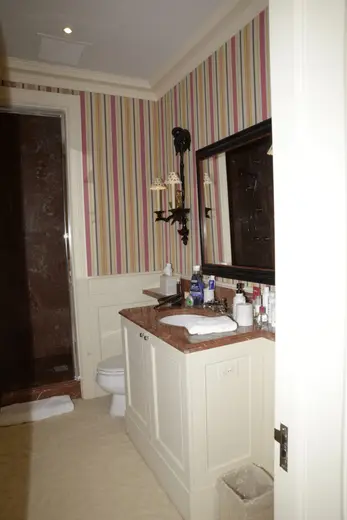 Badezimmer: EFTA00000227 - Bathroom with striped wallpaper a marble countertop and a large mirror
