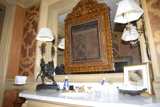 Ванная: EFTA00000140 - Elegant bathroom features ornate wooden mirror marble countertop vintage wa