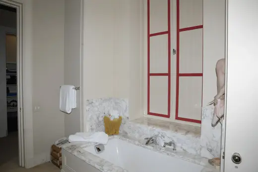Ванная: EFTA00000614 - Bathroom with a white bathtub marble countertop red-framed window and a tow