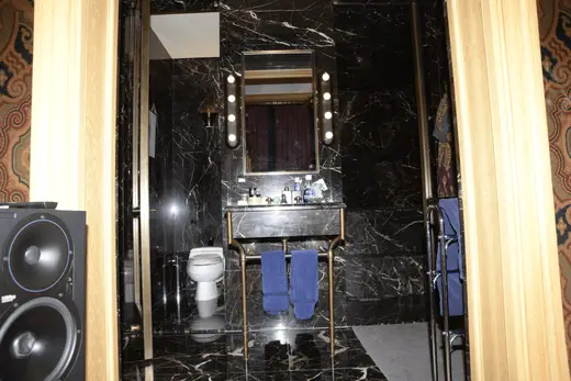 Ванная: EFTA00000173 - Luxurious bathroom with black marble walls a gold-framed mirror with lights
