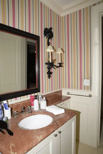 Badezimmer: EFTA00000230 - Bathroom with striped wallpaper a marble countertop and a black-framed mirr