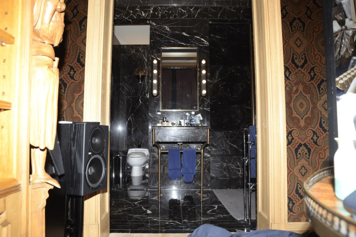 Bagno: EFTA00000654 - Luxurious bathroom with black marble walls a vanity mirror with lights and
