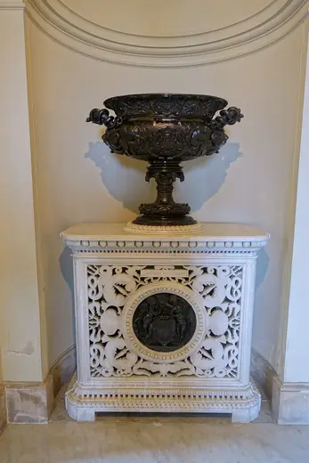 Detalle de superficie: Urn atop Lorandini stove with Carlo Marochetti medallion based on Jean Goujon’s work at Ho