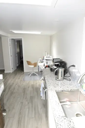 Cucina: EFTA00002082 - Modern kitchen with light wood floors white walls and a granite countertop 