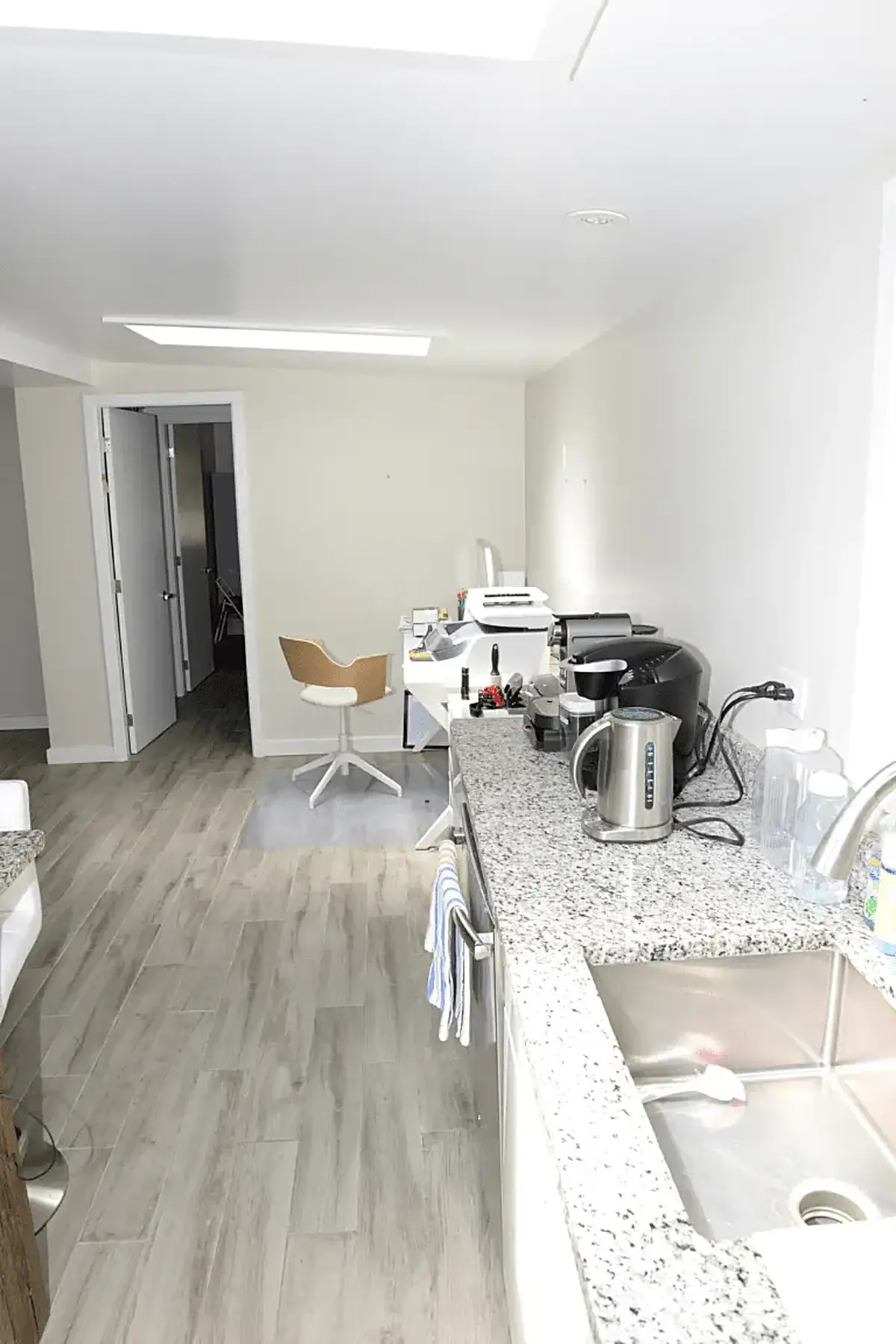 Cocina: EFTA00002082 - Modern kitchen with light wood floors white walls and a granite countertop 