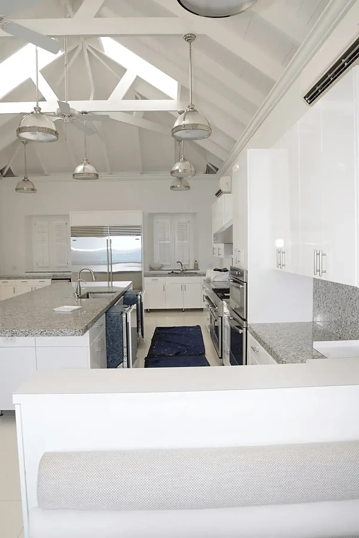 Kitchen: EFTA00001534 - Bright white kitchen with exposed beams pendant lights and granite countert