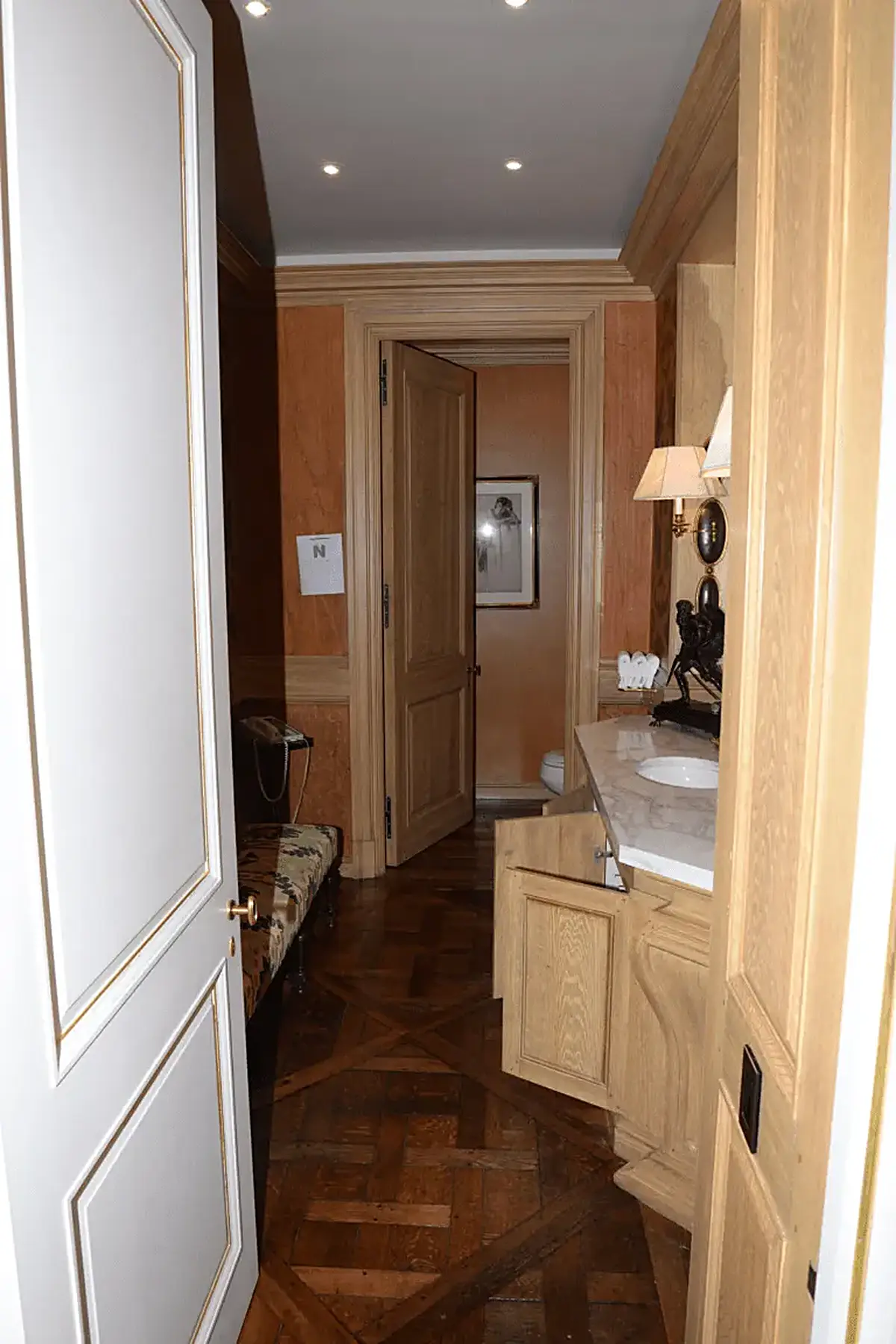 Cocina: EFTA00001435 - Wooden-floored hallway with a white door a marble countertop and warm wood 