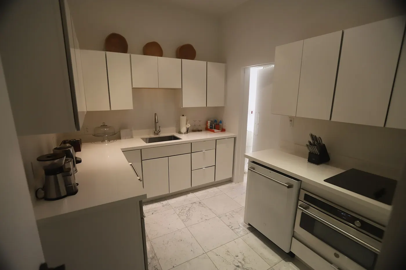 Küche: USVI IMG 5429 - Modern white kitchen with sleek cabinets marble floor and stainless steel