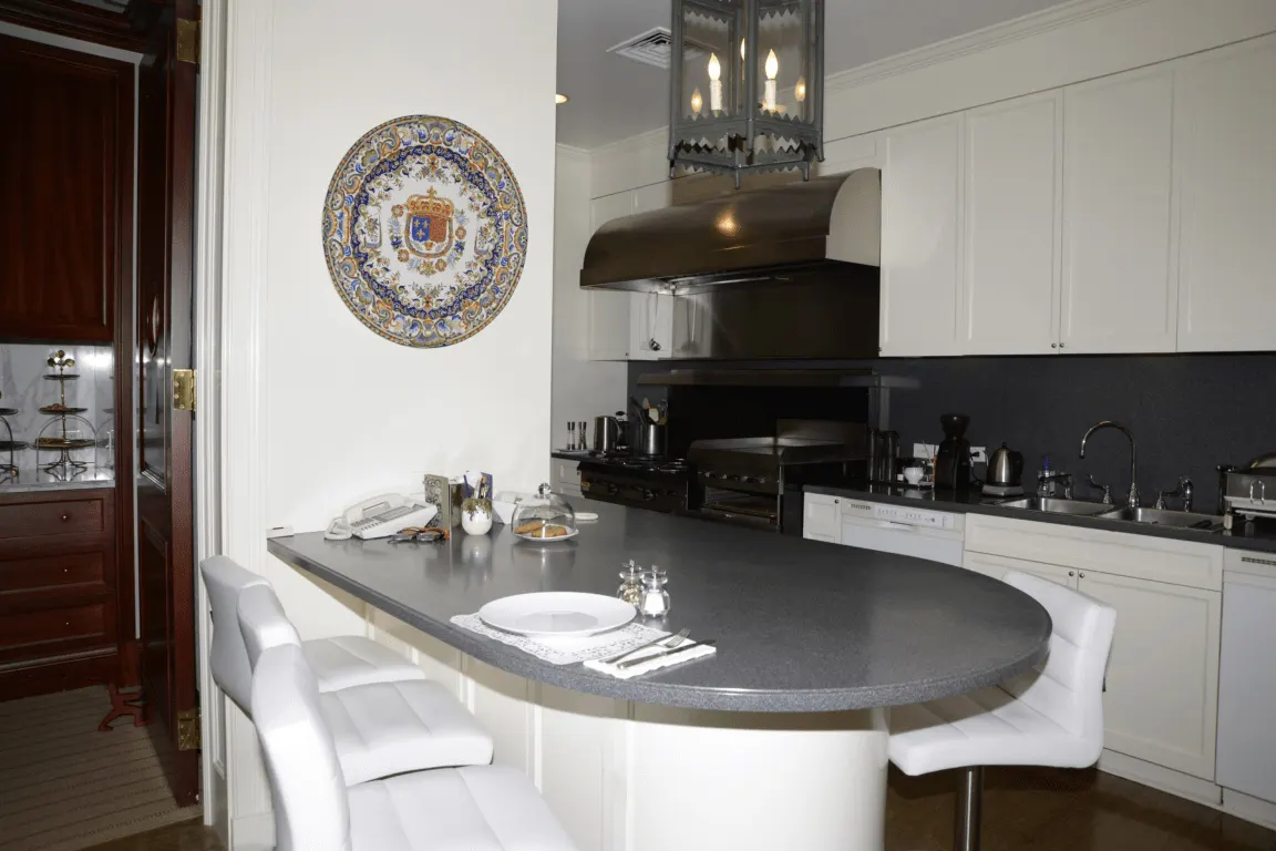 Cucina: EFTA00000072 - Modern kitchen with white cabinets a dark countertop and a decorative plate