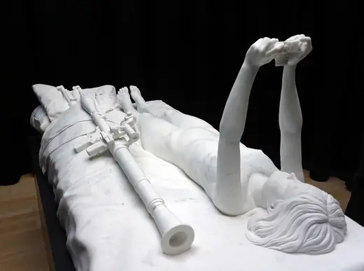 Slab surface: Figure on Bed with Camera and Weapons